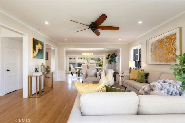 living area featuring a ceiling fan, recessed lighting, light wood-style floors, and ornamental molding