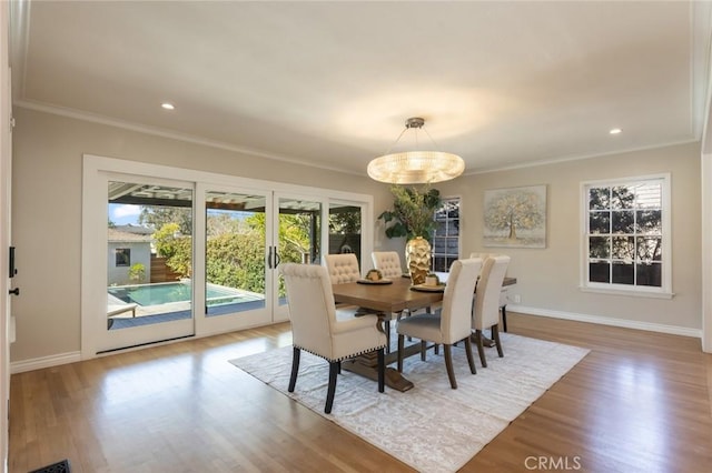 dining space with a wealth of natural light, baseboards, wood finished floors, and ornamental molding