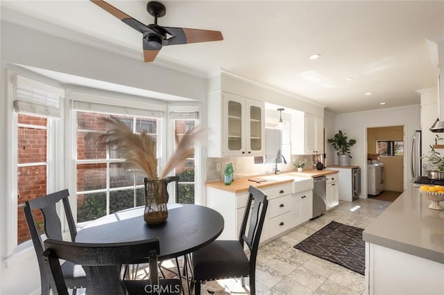 kitchen featuring stainless steel dishwasher, plenty of natural light, separate washer and dryer, and a sink