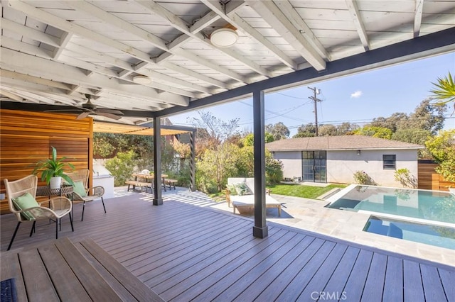 deck featuring an outdoor pool, an outbuilding, and a ceiling fan