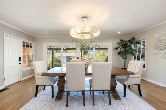 dining room with crown molding, wood finished floors, and a wealth of natural light