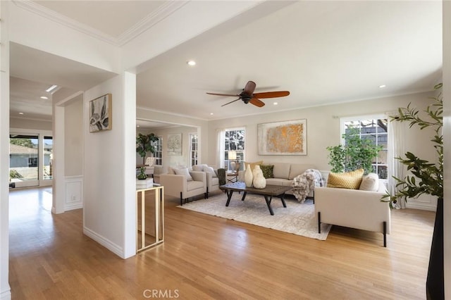 living room with recessed lighting, a healthy amount of sunlight, crown molding, and light wood finished floors