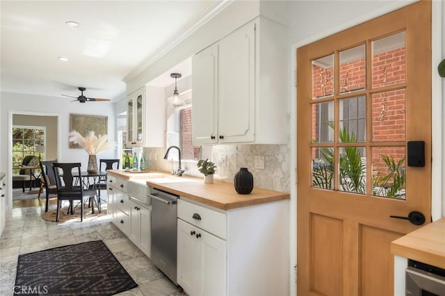 kitchen with backsplash, wooden counters, white cabinets, and stainless steel dishwasher