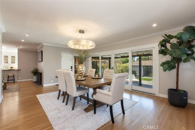 dining room with recessed lighting, baseboards, wood finished floors, and crown molding