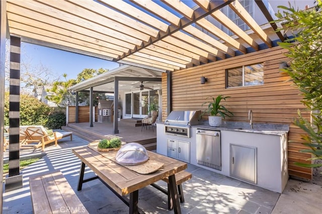 view of patio with a deck, outdoor dining space, an outdoor kitchen, a grill, and a pergola