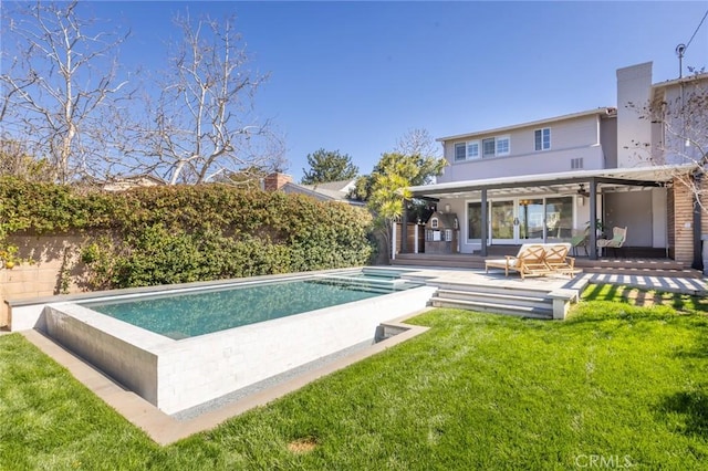 back of property with an outdoor pool, a lawn, and fence