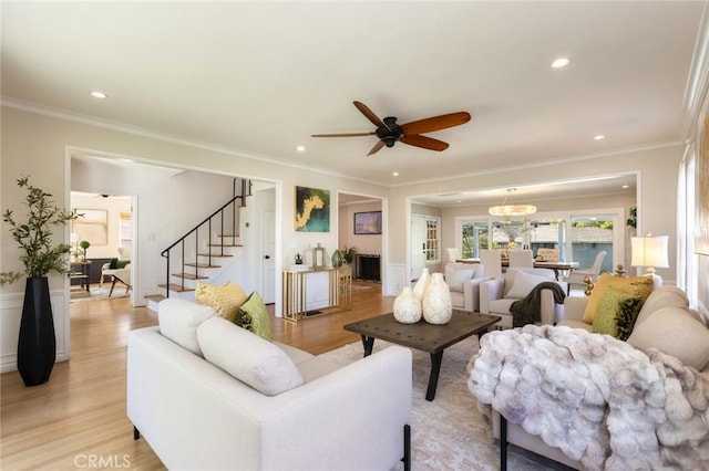 living area with crown molding, stairway, recessed lighting, and light wood-type flooring