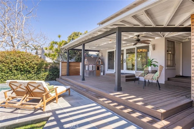 wooden terrace with a swimming pool, french doors, and ceiling fan