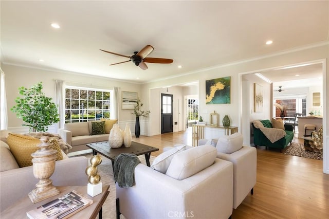 living area with ceiling fan, recessed lighting, light wood-style floors, and ornamental molding