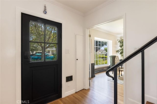 entryway with stairway, light wood-style flooring, and crown molding