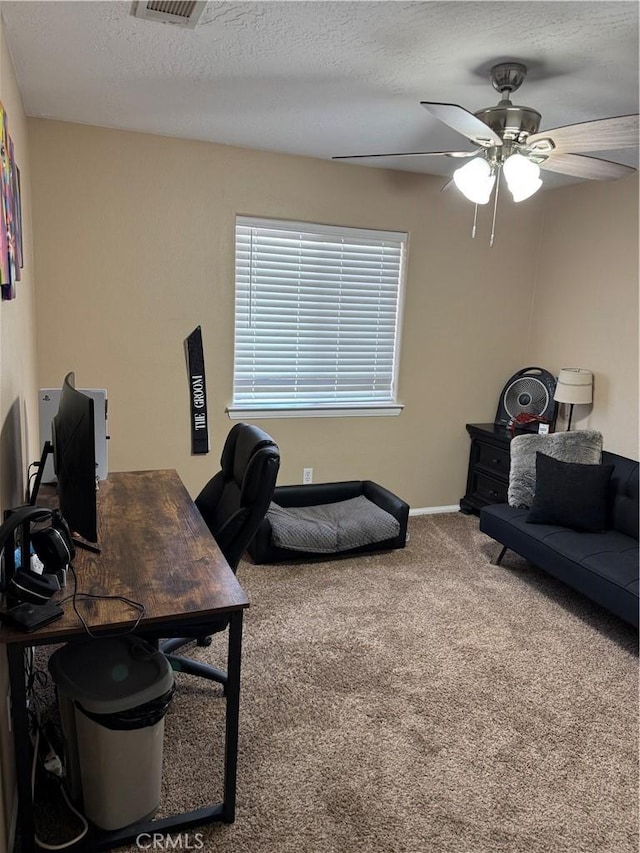 home office featuring visible vents, carpet floors, a textured ceiling, and ceiling fan