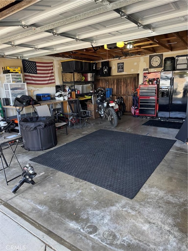 garage with black refrigerator with ice dispenser