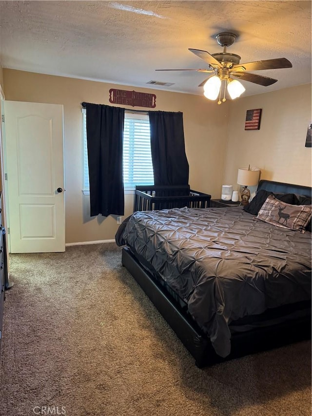 bedroom with visible vents, baseboards, carpet flooring, a textured ceiling, and a ceiling fan