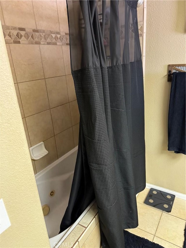 full bath with tile patterned floors, a textured wall, baseboards, and a combined bath / shower with jetted tub