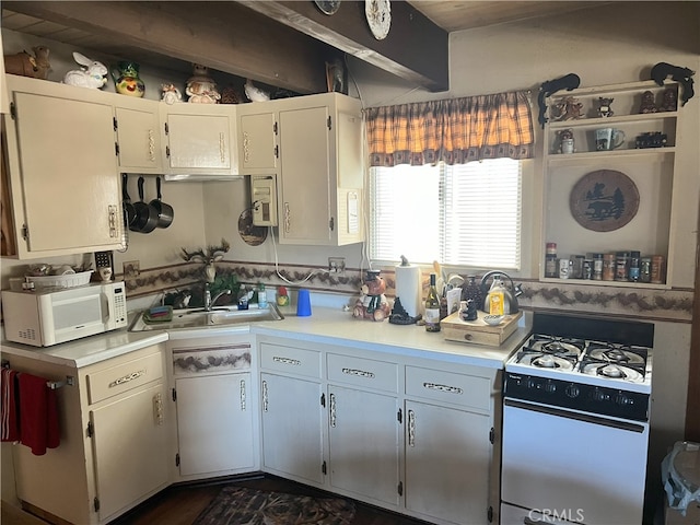 kitchen with beamed ceiling, a sink, gas range oven, light countertops, and white microwave