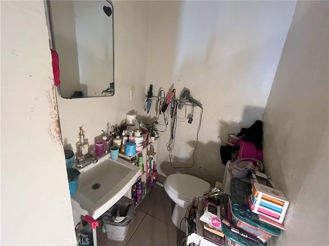 bathroom with tile patterned flooring, toilet, and a sink