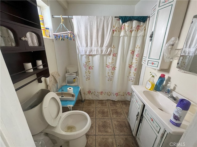 full bath featuring toilet, vanity, and a shower with curtain