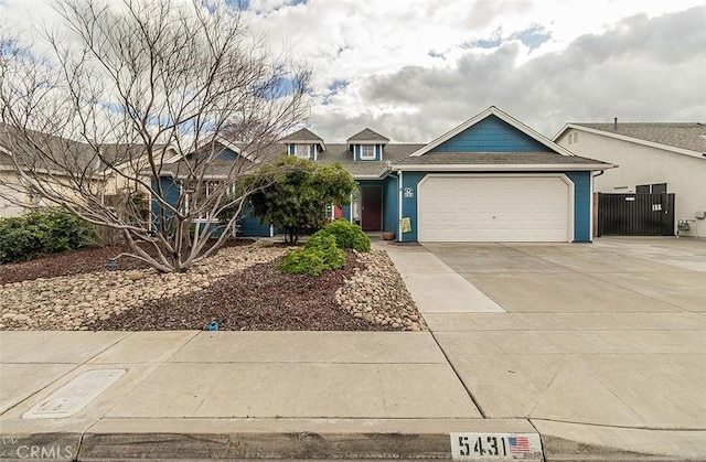 view of front facade featuring an attached garage, driveway, and fence