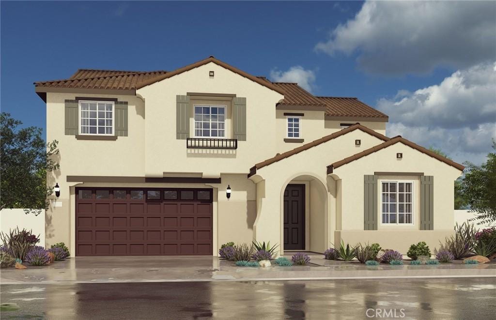 mediterranean / spanish-style home featuring stucco siding, a tiled roof, concrete driveway, and a garage