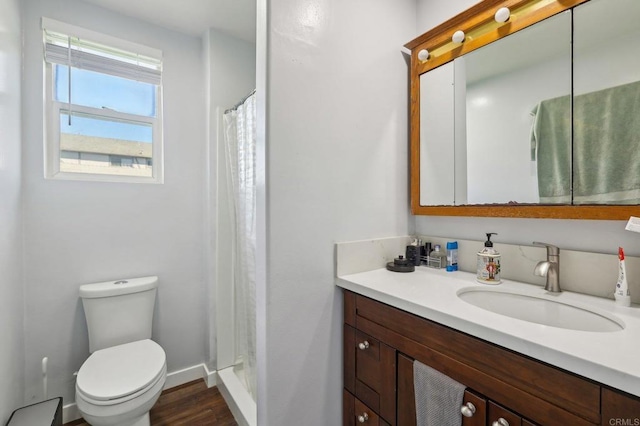 full bath with a shower with curtain, toilet, wood finished floors, baseboards, and vanity