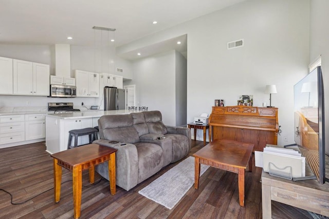 living area featuring dark wood finished floors, recessed lighting, visible vents, and high vaulted ceiling