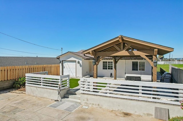 view of front of house with an attached garage, fence private yard, and stucco siding