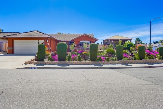 view of front of house with a tile roof, stucco siding, driveway, and an attached garage