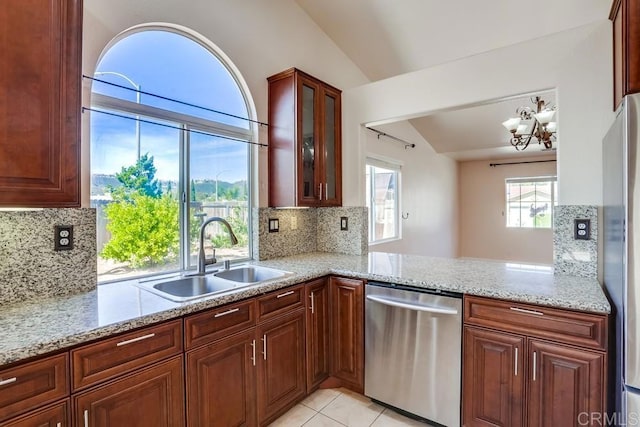 kitchen featuring glass insert cabinets, lofted ceiling, light stone counters, appliances with stainless steel finishes, and a sink