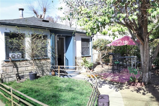 back of house with a patio, fence, and roof with shingles