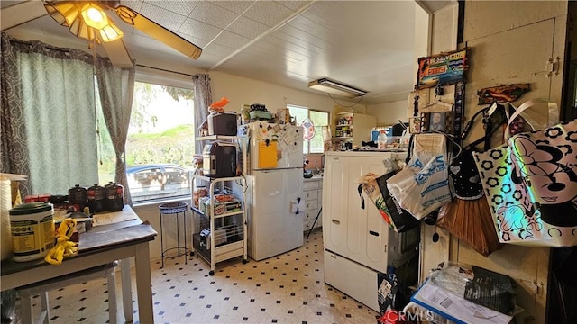 kitchen with light floors, washer / dryer, a ceiling fan, and freestanding refrigerator