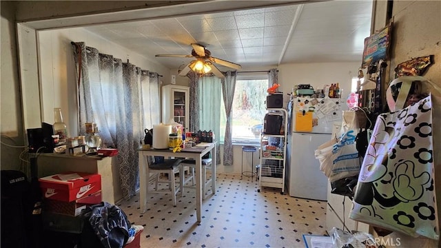 kitchen featuring tile patterned floors, freestanding refrigerator, and a ceiling fan