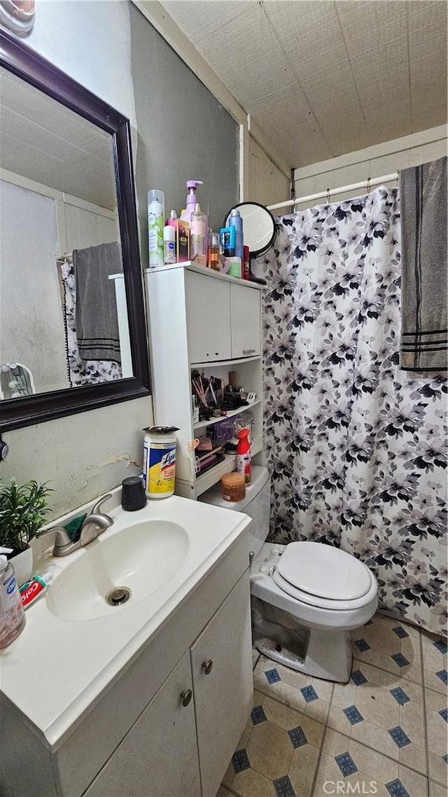 bathroom featuring vanity, toilet, a shower with curtain, and tile patterned flooring