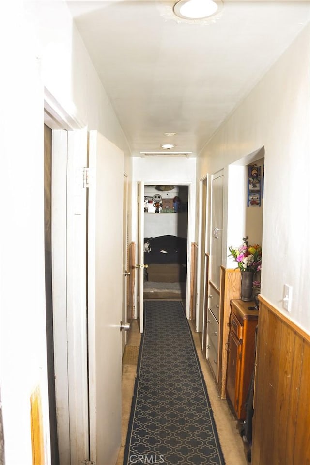 hall featuring wooden walls and wainscoting