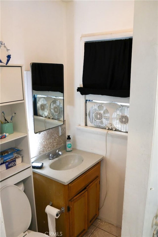 half bathroom with vanity, toilet, and tile patterned flooring