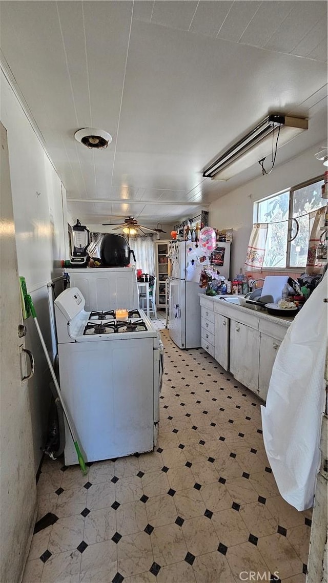 kitchen featuring light floors, white appliances, white cabinets, and a ceiling fan