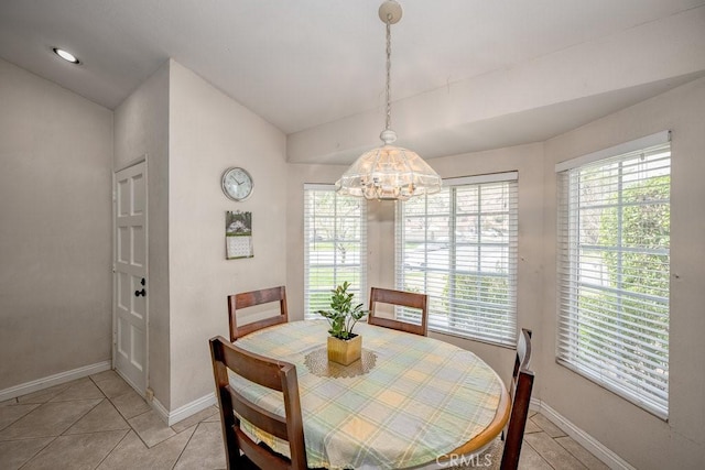 dining area featuring light tile patterned flooring, an inviting chandelier, baseboards, and lofted ceiling