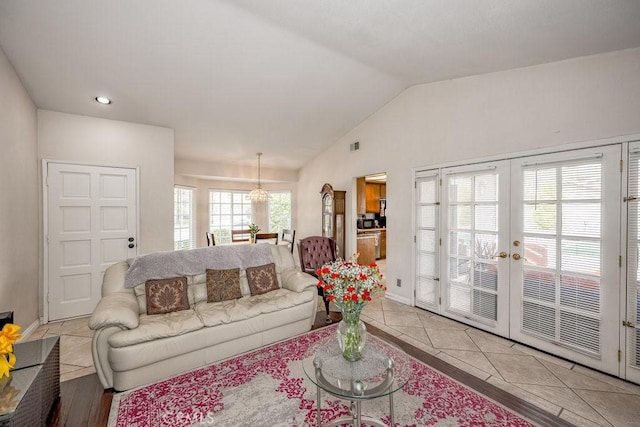 living area with light tile patterned floors, baseboards, lofted ceiling, recessed lighting, and french doors