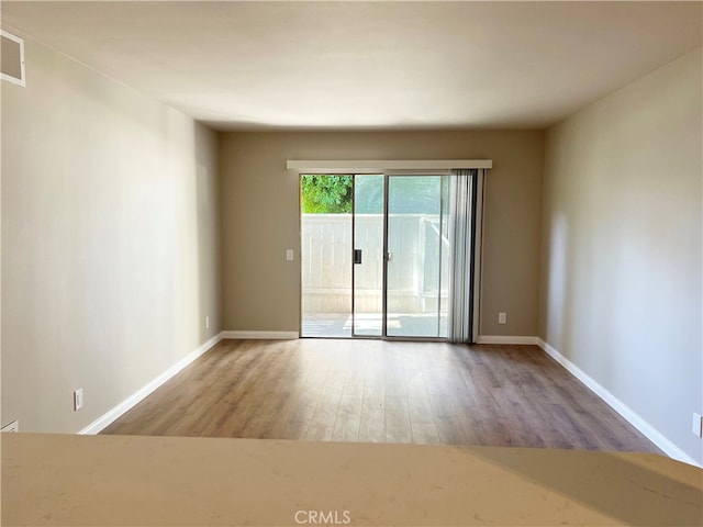 empty room featuring baseboards and wood finished floors