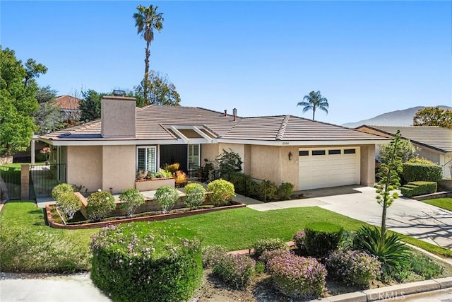 view of front of home featuring a front yard, a chimney, stucco siding, concrete driveway, and a garage