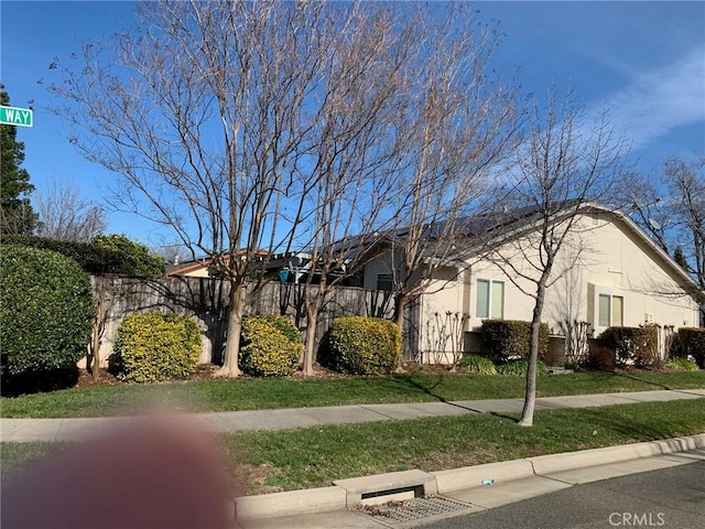 view of front of home featuring stucco siding and a front lawn