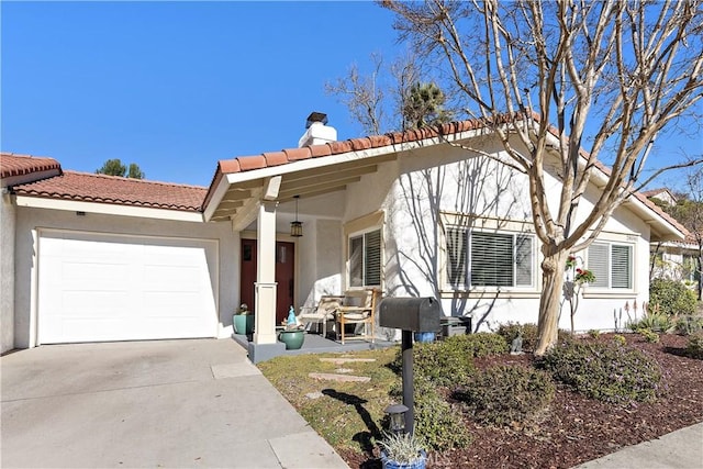 view of front of home with a tile roof, stucco siding, a chimney, driveway, and an attached garage