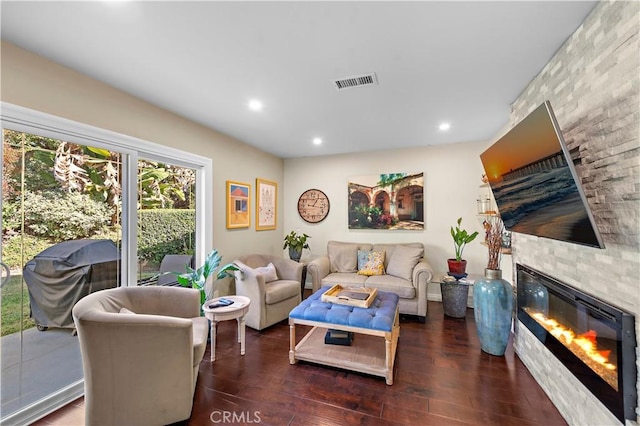 living room with recessed lighting, wood finished floors, visible vents, and a large fireplace