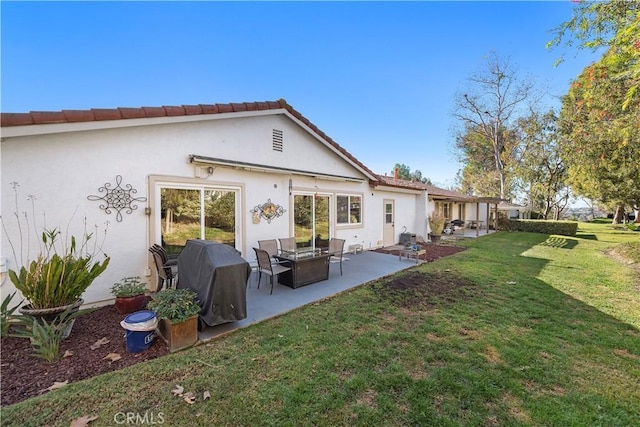 back of house with a patio area, stucco siding, and a yard