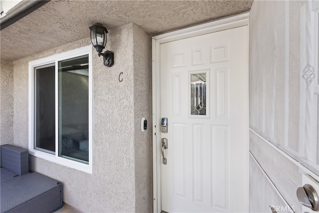 doorway to property featuring stucco siding