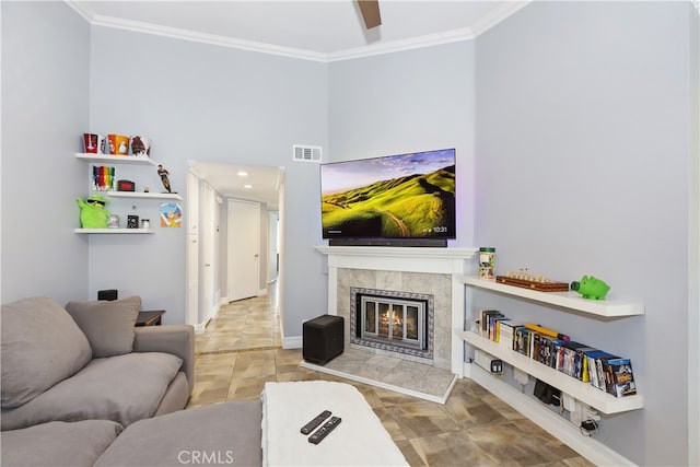 living area featuring visible vents, a fireplace, crown molding, and baseboards