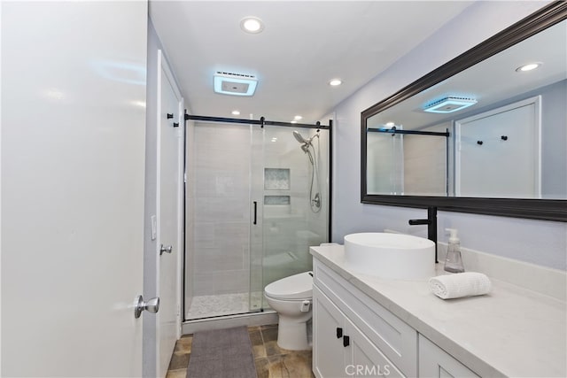 bathroom with recessed lighting, a shower stall, toilet, and vanity