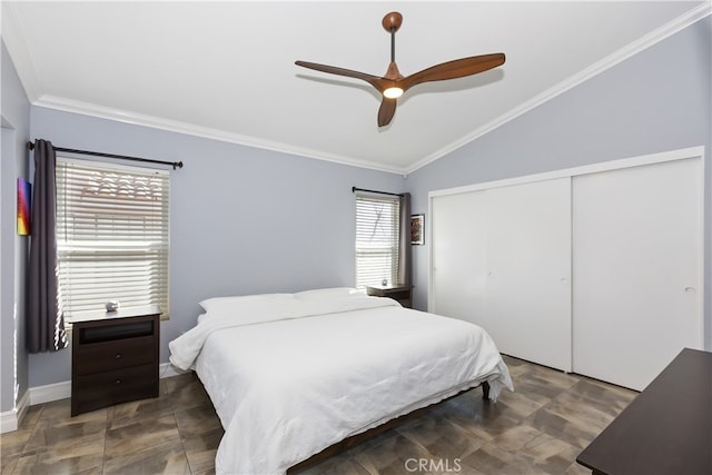 bedroom featuring a closet, a ceiling fan, lofted ceiling, and ornamental molding