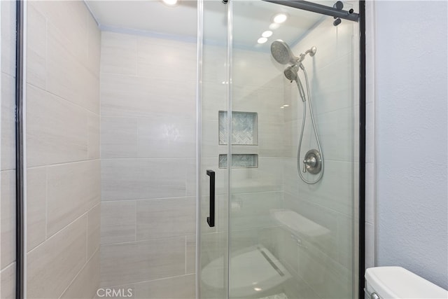 bathroom featuring a stall shower and toilet