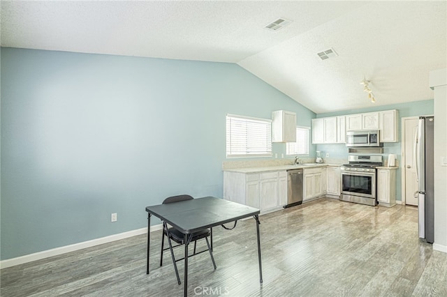 kitchen featuring visible vents, light wood-style flooring, appliances with stainless steel finishes, and a sink