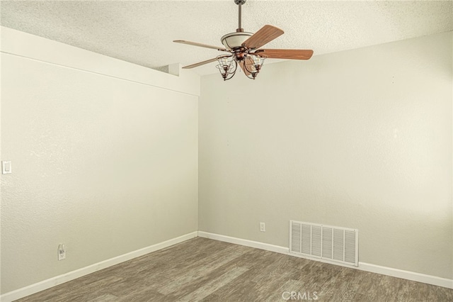 spare room with visible vents, a textured ceiling, wood finished floors, baseboards, and ceiling fan